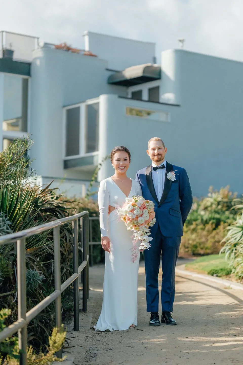 Bride and groom on a coastal path in Laguna Beach