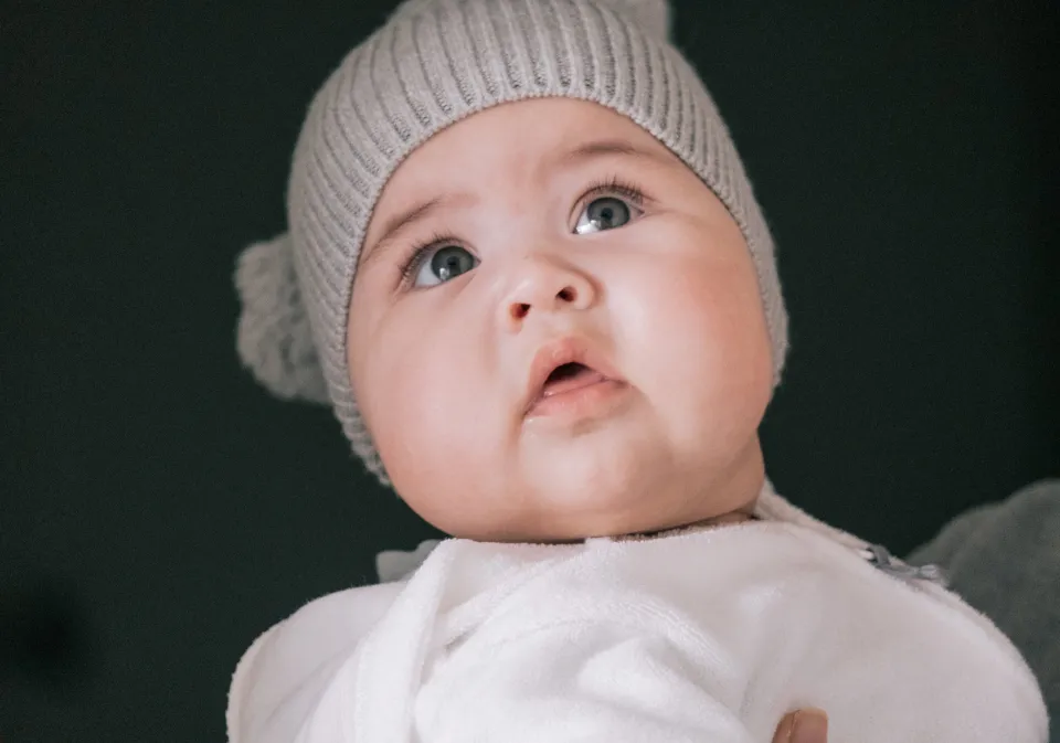 Baby in a knit hat looking up