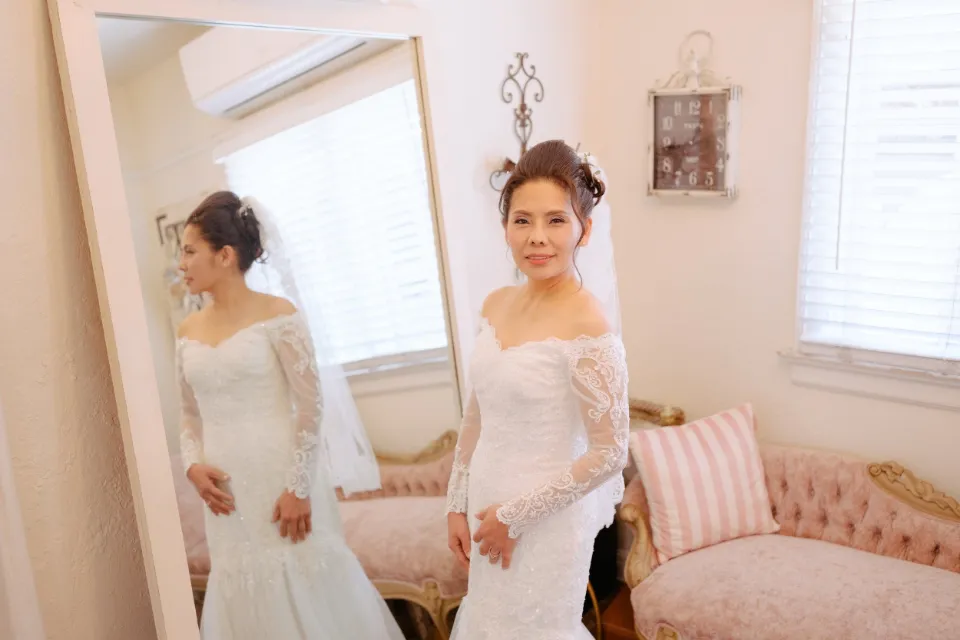Bride in a lace gown reflected in a mirror while getting ready