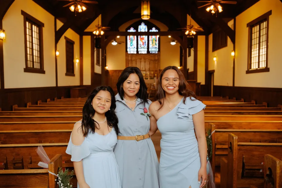Three bridesmaids in powder blue inside a chapel